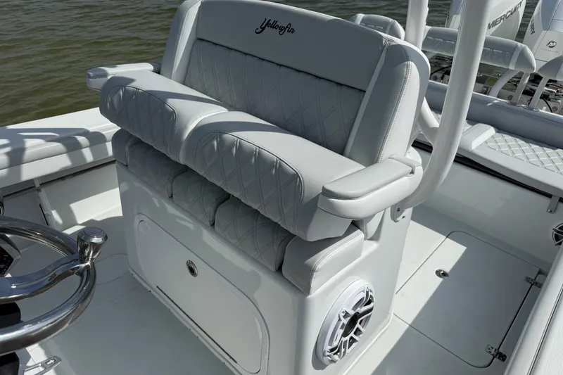 Slide: The Image of 2023 Yellowfin 26 Hybrid boat interior with cushioned seating and steering wheel. - 34