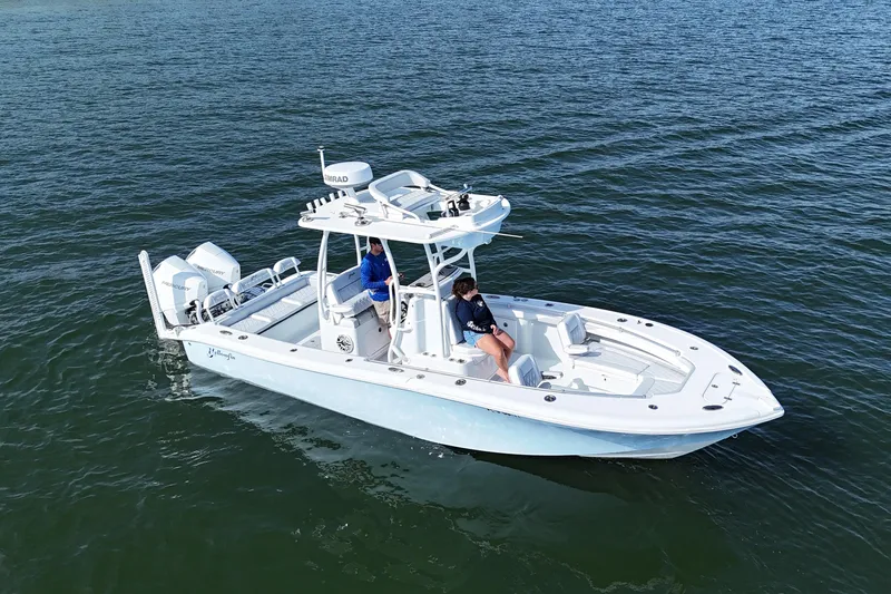 Slide: The Image of 2023 Yellowfin 26 Hybrid boat cruising on open water with two passengers. - 4