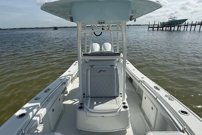 Slide: The Image of 2023 Yellowfin 26 Hybrid boat on calm water, showcasing sleek design and spacious deck. - 48