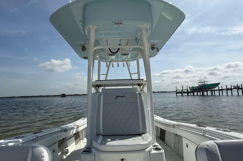 Slide: The Image of 2023 Yellowfin 26 Hybrid boat on calm water, showcasing seating and T-top. - 51