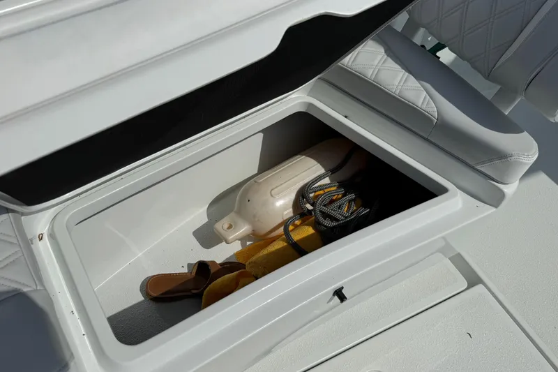 Slide: The Image of Storage compartment on 2023 Yellowfin 26 Hybrid boat with fender, rope, and sandal. - 59