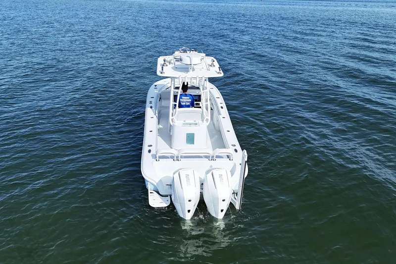Slide: The Image of 2023 Yellowfin 26 Hybrid boat on open water, rear view. - 6