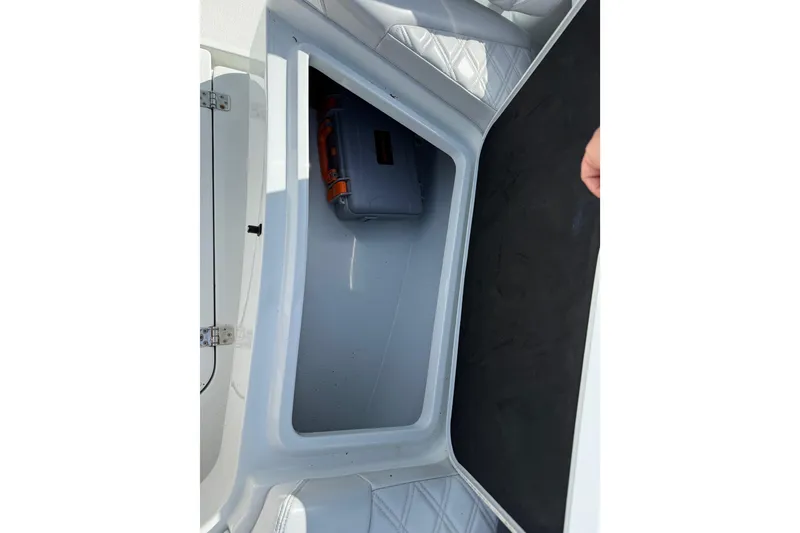 Slide: The Image of Storage compartment in 2023 Yellowfin 26 Hybrid boat, featuring a secure latch and interior space. - 60