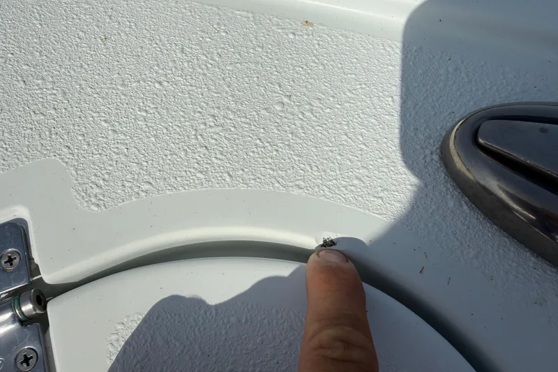 Slide: The Image of Close-up of a 2023 Yellowfin 26 Hybrid boat surface with a finger pointing at a small detail. - 63