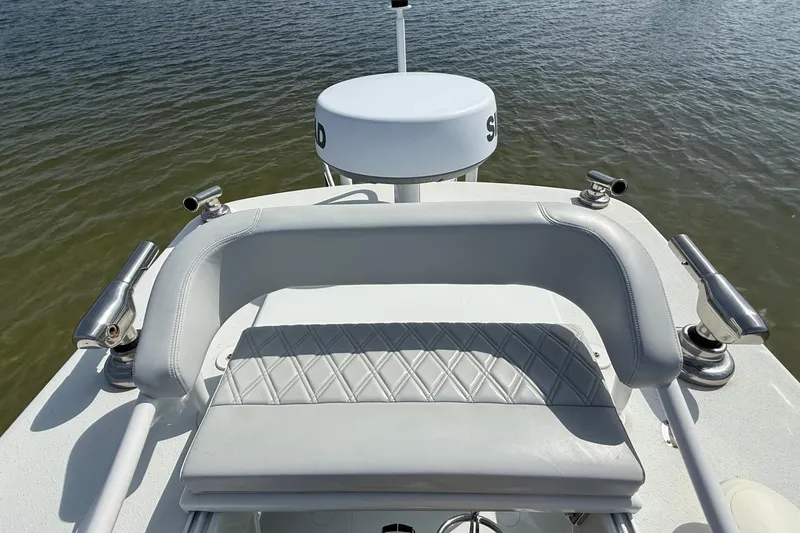 Slide: The Image of 2023 Yellowfin 26 Hybrid boat with cushioned seating and rod holders on calm water. - 66
