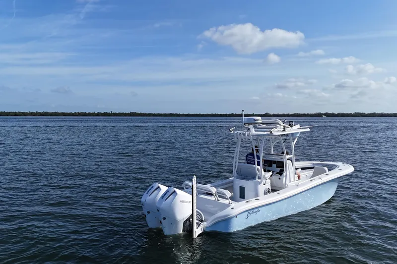 Slide: The Image of 2023 Yellowfin 26 Hybrid boat on calm water under a clear blue sky. - 7