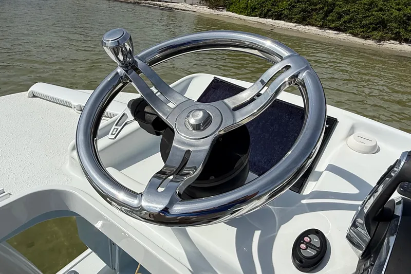 Slide: The Image of Steering wheel of 2023 Yellowfin 26 Hybrid boat, docked near shoreline. - 70