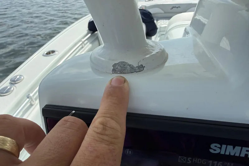 Slide: The Image of 2023 Yellowfin 26 Hybrid boat with a finger pointing at a chipped paint area. - 77