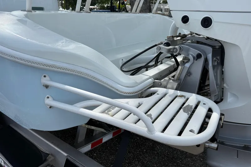 Slide: The Image of 2023 Yellowfin 26 Hybrid boat stern with ladder and engine components. - 79