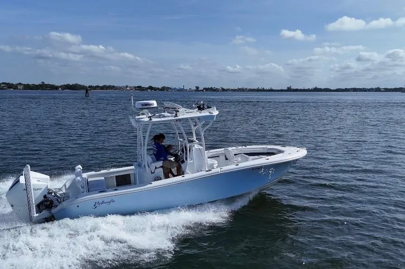 Slide: The Image of 2023 Yellowfin 26 Hybrid boat cruising on open water under a clear sky. - 8