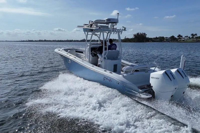Slide: The Image of 2023 Yellowfin 26 Hybrid boat cruising on open water with dual Mercury engines. - 9