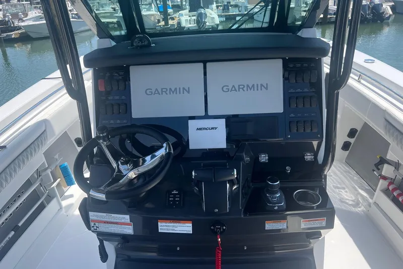 Slide: The Image of 2023 Blackfin 302 CC boat dashboard with Garmin displays and Mercury controls. - 10