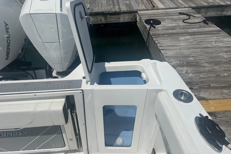 Slide: The Image of 2023 Blackfin 302 CC boat with open storage compartment and Mercury engine at dock. - 15