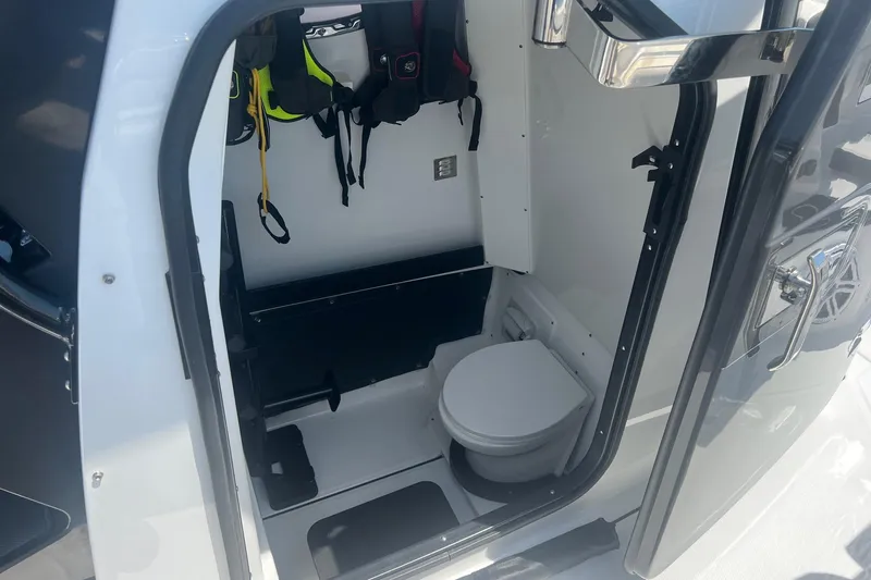 Slide: The Image of 2023 Blackfin 302 CC boat interior with compact marine toilet and storage area. - 18