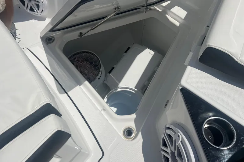 Slide: The Image of Open storage compartment on 2023 Blackfin 302 CC boat, featuring speakers and cup holders. - 21
