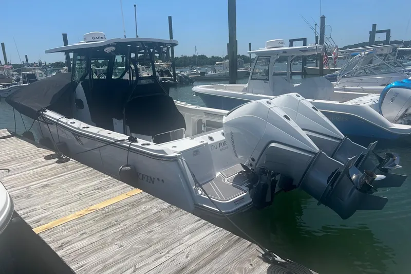 Slide: The Image of 2023 Blackfin 302 CC boat docked with twin outboard engines in a marina. - 23