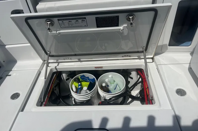 Slide: The Image of Open storage compartment on 2023 Blackfin 302 CC boat with cleaning supplies. - 24