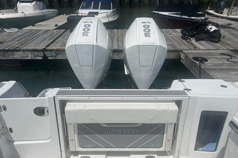 Slide: The Image of 2023 Blackfin 302 CC boat with twin Mercury outboard engines at a dock. - 25