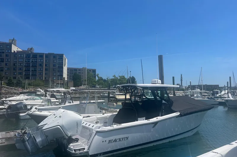 Slide: The Image of 2023 Blackfin 302 CC boat docked in a marina under a clear blue sky. - 28
