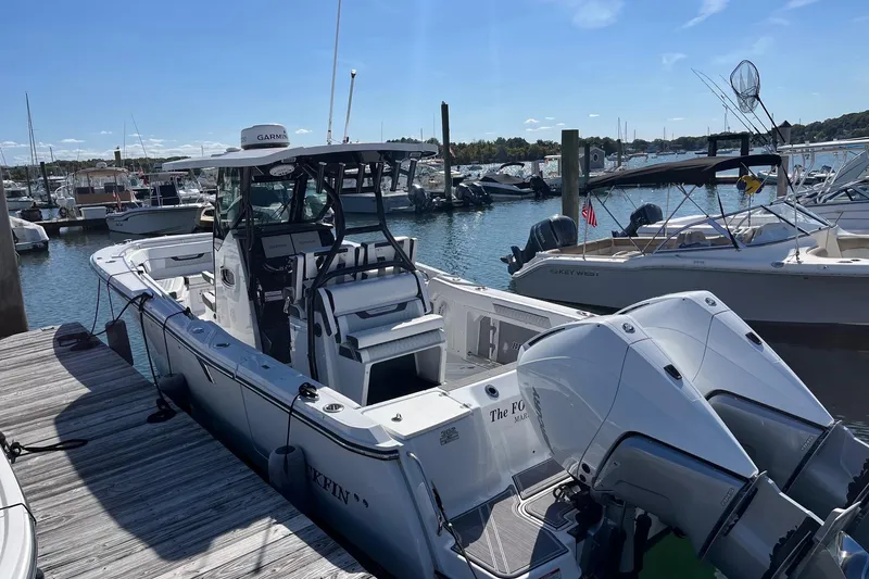 Slide: The Image of 2023 Blackfin 302 CC boat docked at marina with twin engines and clear blue sky. - 3