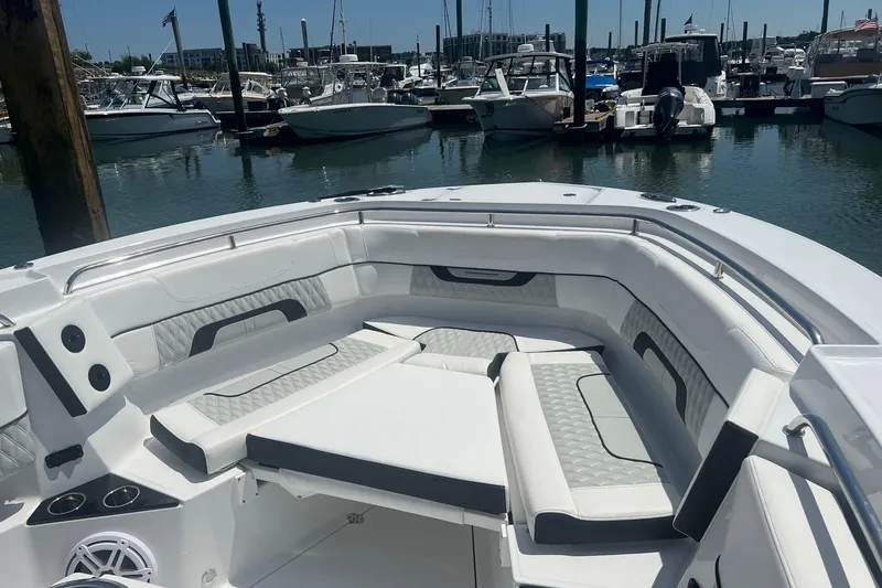 Slide: The Image of 2023 Blackfin 302 CC boat interior with luxurious seating at a marina. - 4