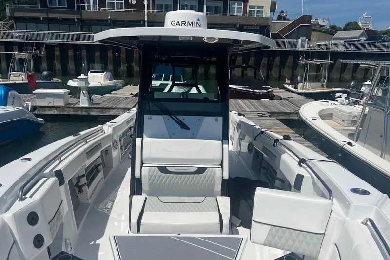 Slide: The Image of 2023 Blackfin 302 CC boat interior at marina, featuring Garmin equipment. - 7