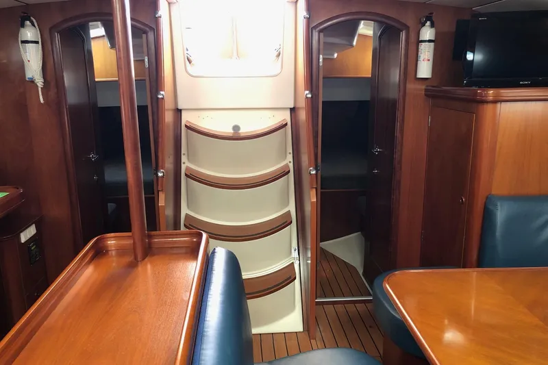 Slide: The Image of Interior of a 2001 Beneteau 50 yacht with wooden finishes and seating area. - 13