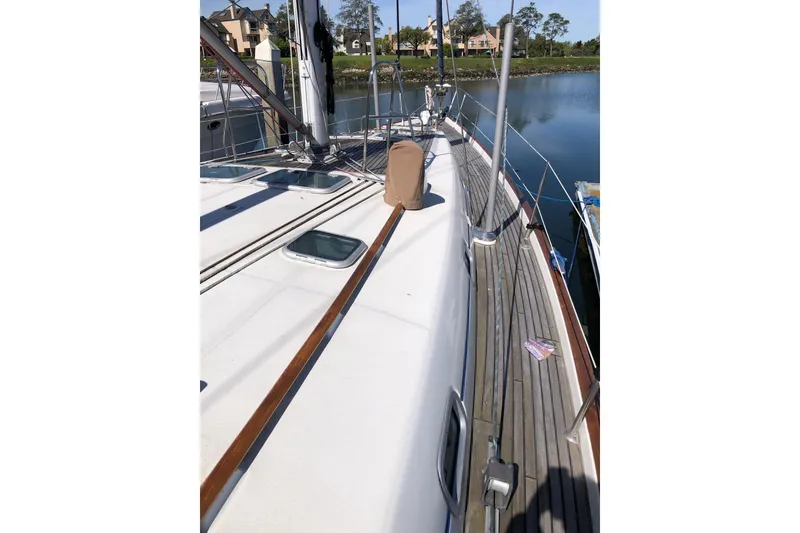 Slide: The Image of Deck view of a 2001 Beneteau 50 sailboat docked by calm waters. - 18