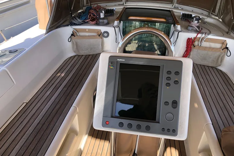 Slide: The Image of Cockpit of 2001 Beneteau 50 sailboat with navigation equipment and teak flooring. - 19