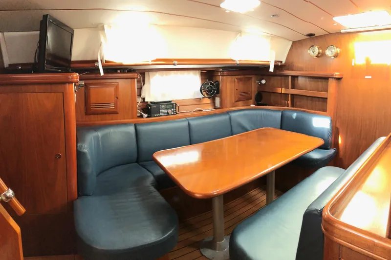 Slide: The Image of Interior of a 2001 Beneteau 50 yacht with wooden furnishings and blue seating. - 2