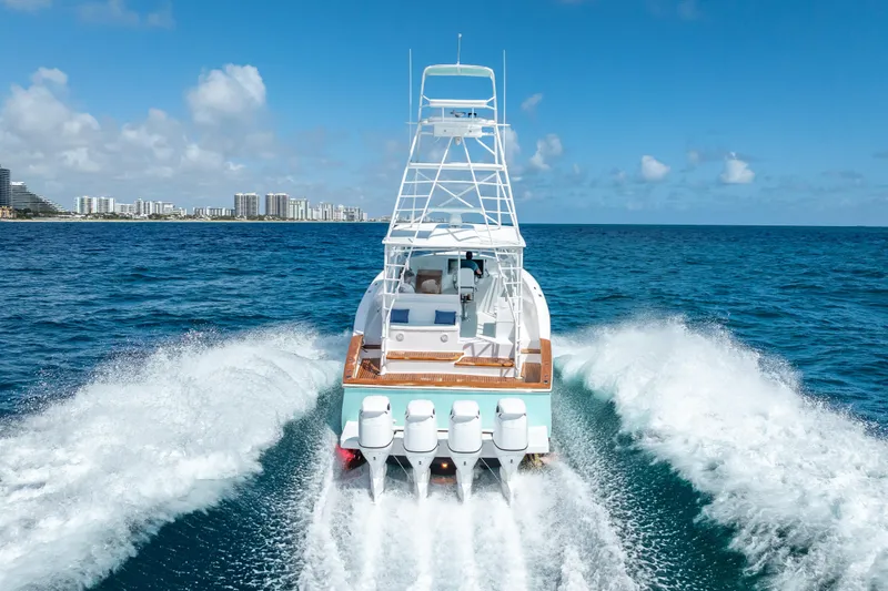 Slide: The Image of 2025 Rybovich Custom Margaritavich yacht cruising on open ocean near city skyline. - 12