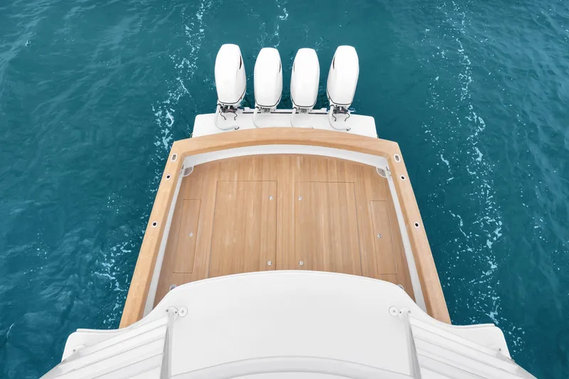 Slide: The Image of Rybovich Custom Margaritavich 2025 boat with wooden deck and four engines on blue water. - 40