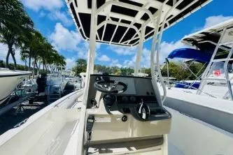 Slide: The Image of 2017 Boston Whaler 240 Outrage boat with center console, docked under clear blue sky. - 5