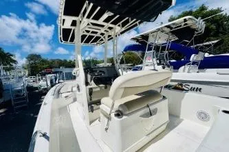Slide: The Image of 2017 Boston Whaler 240 Outrage boat with seating and console, docked under blue sky. - 4