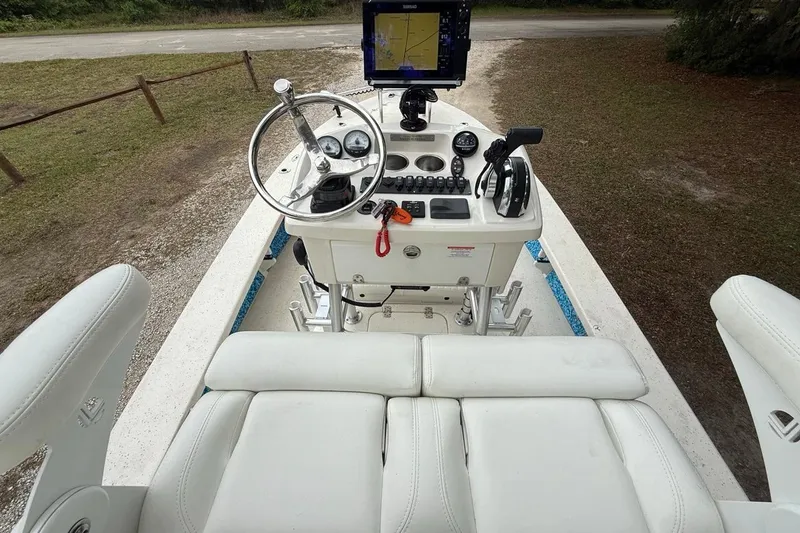 Slide: The Image of 2021 Young Boats Gulf Shores 24 cockpit with steering wheel, controls, and navigation system. - 10