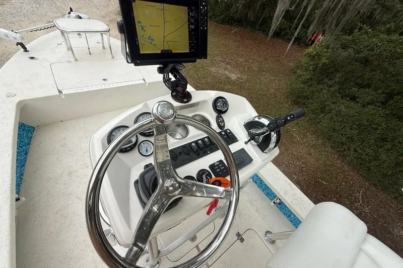 Slide: The Image of Steering console of 2021 Young Boats Gulf Shores 24 with navigation display and controls. - 11