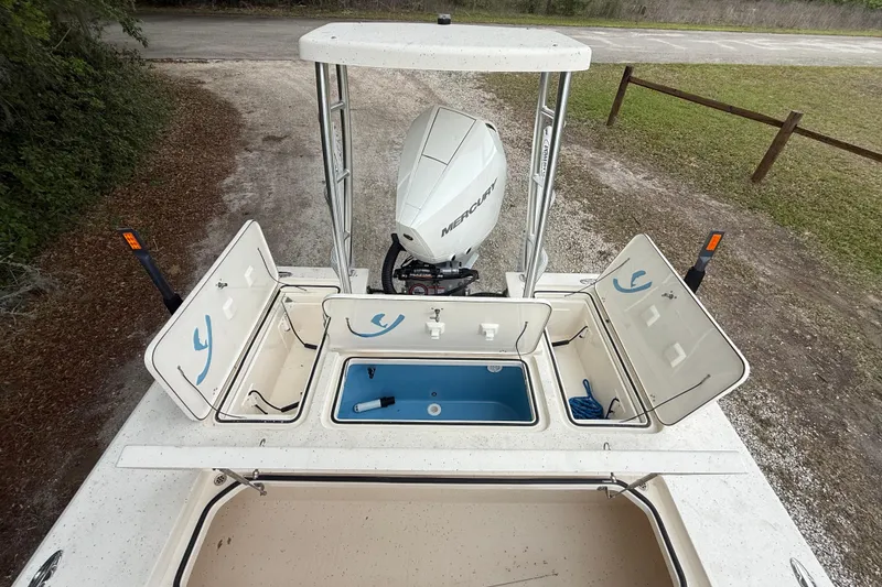 Slide: The Image of 2021 Young Boats Gulf Shores 24 with open storage compartments and Mercury outboard motor. - 17