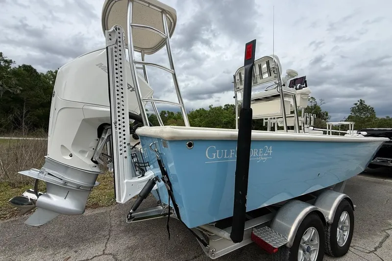 Slide: The Image of 2021 Young Boats Gulf Shores 24 on trailer, featuring a powerful outboard motor. - 2