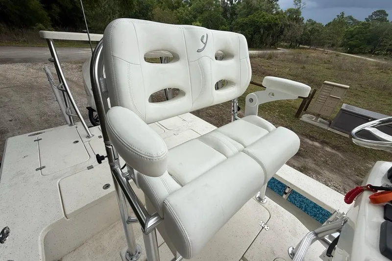 Slide: The Image of White captain's chair on 2021 Young Boats Gulf Shores 24, featuring cushioned seating and armrests. - 9