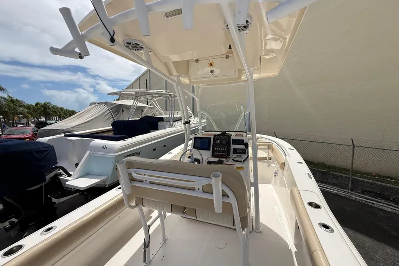 Slide: The Image of 2016 Sea Fox 226 Commander boat interior with helm and seating, docked outdoors. - 30