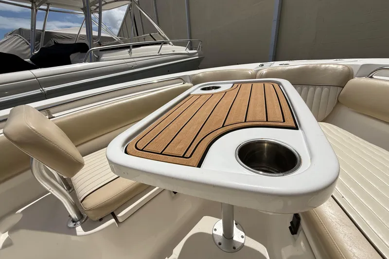 Slide: The Image of 2016 Sea Fox 226 Commander boat interior with cushioned seating and wooden table. - 35