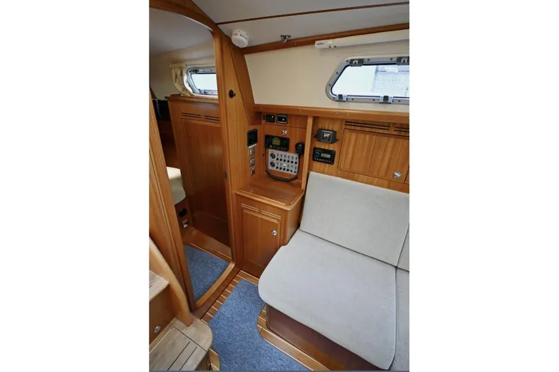 Slide: The Image of Interior of 2020 Hallberg Rassy 310 yacht, featuring wooden cabinetry and navigation controls. - 6