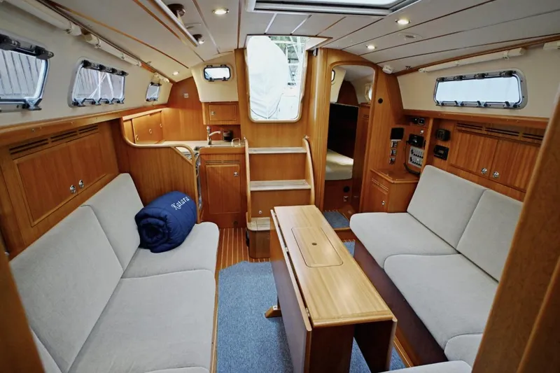 Slide: The Image of Interior of 2020 Hallberg Rassy 310 yacht with wooden finish and cozy seating. - 7