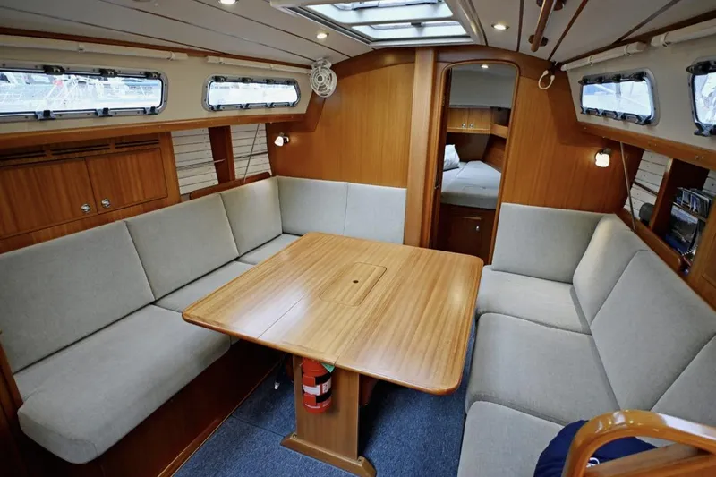 Slide: The Image of Interior of 2020 Hallberg Rassy 310 yacht with cozy seating and wooden table. - 8