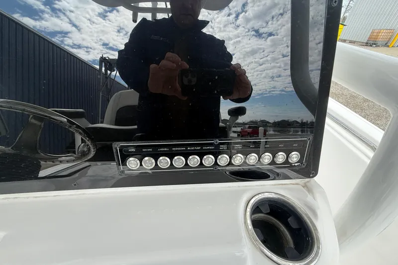 Slide: The Image of 2025 Tidewater 198 CC Adventure boat dashboard with control panel and cup holder. - 13