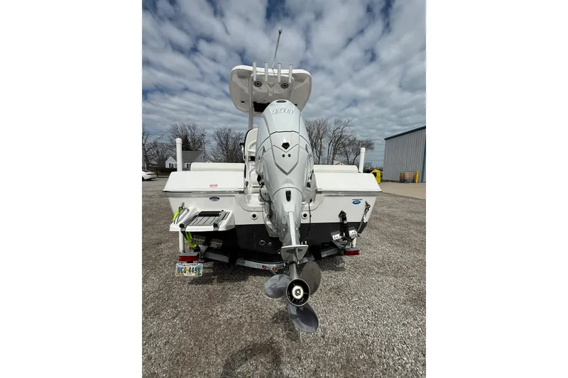 Slide: The Image of 2025 Tidewater 198 CC Adventure boat, rear view with outboard motor, parked on gravel. - 21