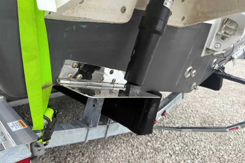 Slide: The Image of 2025 Tidewater 198 CC Adventure boat trailer with green strap and metal hinge detail. - 4