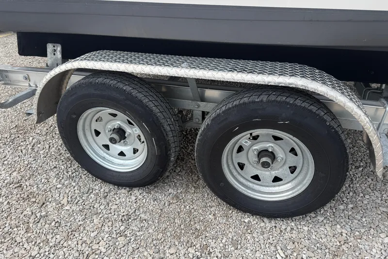 Slide: The Image of Trailer wheels of a 2025 Tidewater 198 CC Adventure boat on gravel. - 8