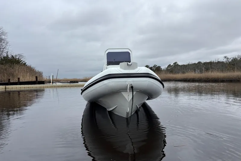 Slide: The Image of Airrib 18 boat on calm water, overcast sky, 2026 model. - 6
