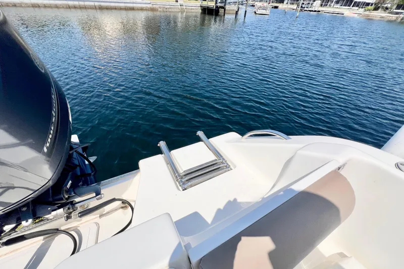 Slide: The Image of 2013 Key West 203 DFS boat with motor and swim ladder on calm water. - 2